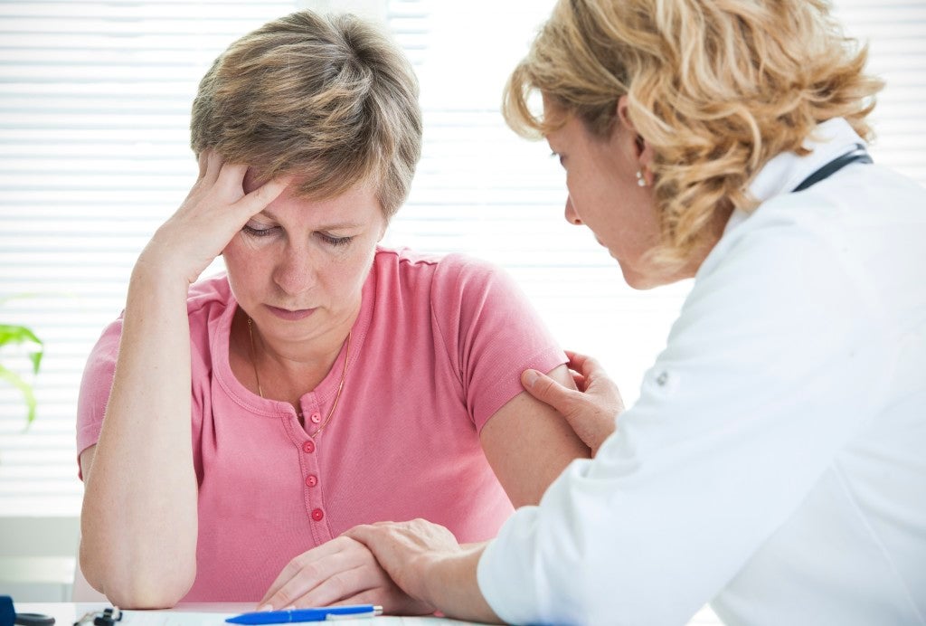 Mid adult woman talking to doctor about her diagnosis