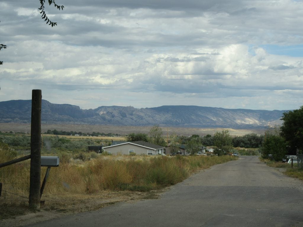Scenic view of rural Utah with mountains and clouds in the distance.
