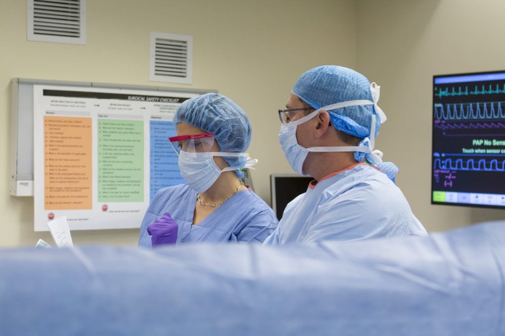 Surgeons prepare for an operation with the checklist in the background