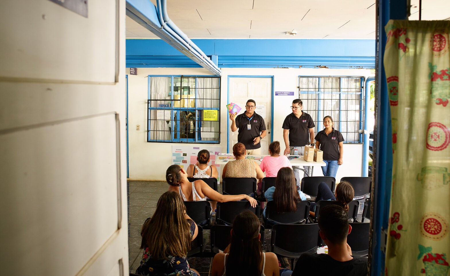 Medical workers give a presentation on reproductive health to a group of young adults.