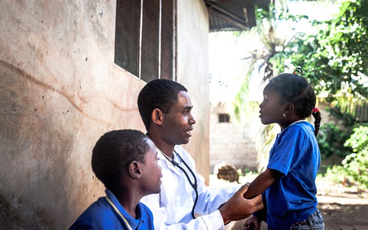 A doctor with two children in Africa.