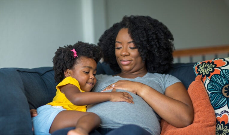 African American mother and daughter smiling at home.