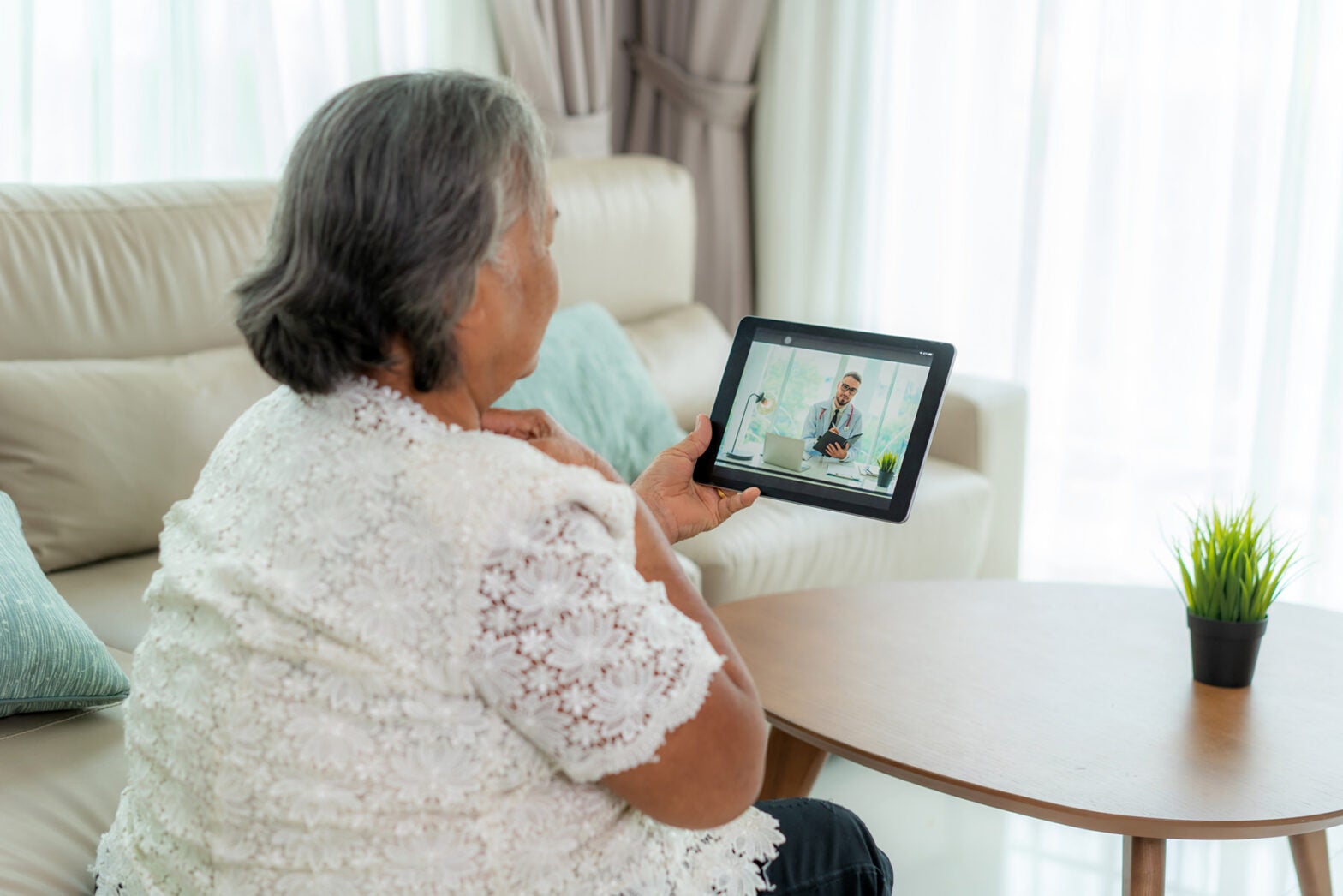 Elderly woman making video call with her doctor from home.