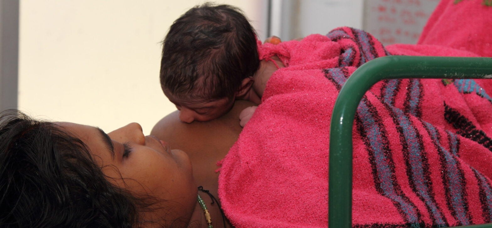 A mother breastfeeding a newborn baby